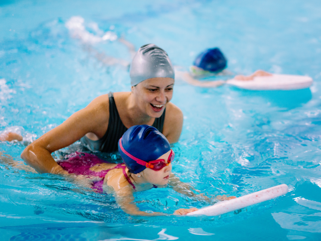 Frau mit Kleinkind im Schwimmkurs