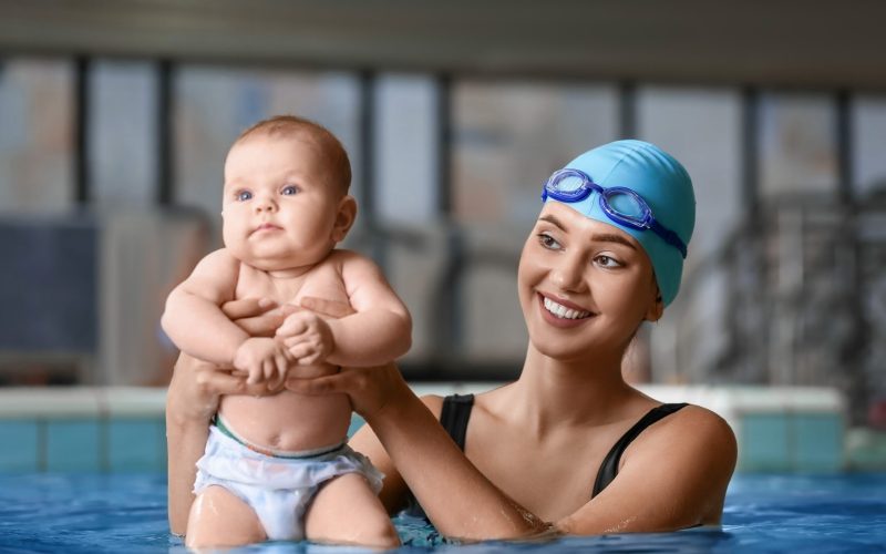 Female,Coach,With,Adorable,Baby,In,Swimming,Pool